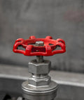 Close-up of a Tough As Nails Cast Iron Shutoff Hand Wheel with red finish on a water fitting
