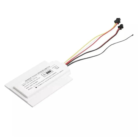 White electronic component with wires, likely a sensor or control unit, isolated on a white background.