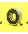 Heavy Duty 607 Hybrid Ceramic Ball Bearings With Si3N4 Balls And Steel Rings For High Speed Motor Spindles And Industrial Machines ABEC-1 Precision Smooth Running Setup on yellow background with steel balls.