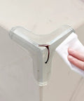 Triangular PVC Corner Protectors Set Of 10 With Corner Brace Design for desktops being wiped clean by a hand.