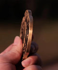 Side view of Dope Antique Copper Samurai Tsuba Fuchi Kashira Menuki Set With Dragon Phoenix Buddha Demon Floral Motif, held by hand