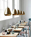 Slap This Modern Single Head Wall Sconce On Your Space And Watch The Vibes Level Up Featuring Sleek Polished Iron Build And Minimalist Aesthetics Ideal For Restaurants Bars And Bedrooms with gold pendant lights and wooden tables.