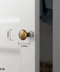 Real Deal Antique Brass Cabinet Knobs 1 1/4 Inch Round Sunburst Design mounted on white cabinet door with measurements.