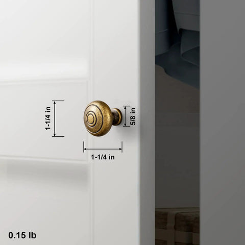 Real Deal Antique Brass Cabinet Knobs 1 1/4 Inch Round Sunburst Design mounted on white cabinet door with measurements.