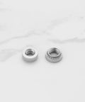 Pack Of Knurled Self Clinching Nuts M3 M4 M5 M6 M8 Crafted From Solid 304 Stainless Steel Rivet Nut Fasteners side view on marble background.
