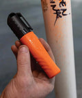 Person holding orange XL Chisel Tip Permanent Marker For Multi Surface Jobsite Use Black Ink That Writes On Wet Oily And Dry Surfaces.