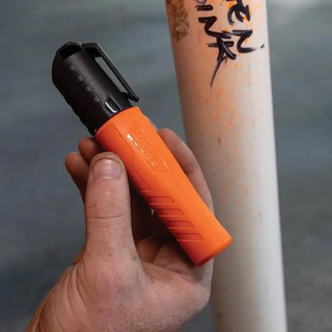 Person holding orange XL Chisel Tip Permanent Marker For Multi Surface Jobsite Use Black Ink That Writes On Wet Oily And Dry Surfaces.