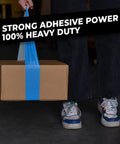 Person holding a cardboard box wrapped with blue heavy-duty tape, emphasizing strong adhesive and durability.