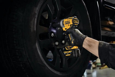 12V Max 3/8 Inch Cordless Impact Wrench Kit in use tightening a wheel lug on a black tire, showcasing portability and precision.