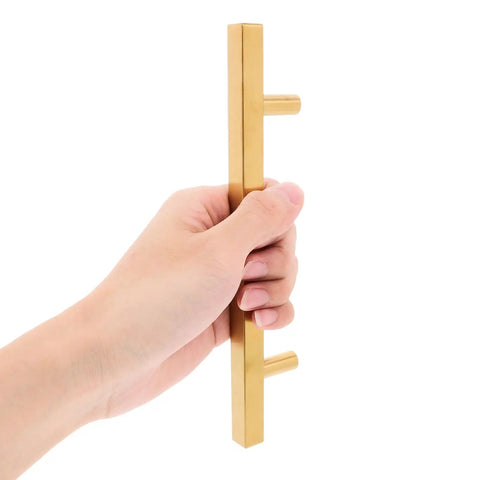 Hand holding a Five Pack 128mm Gold Kitchen Cabinet Handles And Drawer Pulls For Wardrobe Cupboard Doors Polished Finish Cabinet Hardware