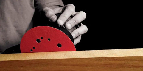 Person using red Hook And Lock ROS Sanding Discs For Wood Metal And Plastics 5 Inch 120 Grit on wooden surface, 5 hole