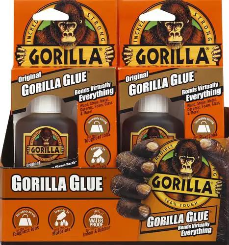 Heavy Duty Waterproof Polyurethane Wood Glue and Multi-Purpose Strong Adhesive that Bonds Wood Metal Stone Glass and More Like Crazy while Expanding to Fill Gaps in 2 Ounce Container in a packaging display.