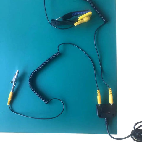 ESD anti-static grounding kit with wrist strap and coiled ground cord; yellow banana plug leads on teal work surface.