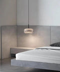 Resin Pendant Light, Gold 3 Color LED Hanging Fixture for Living Room above a modern bed in a stylish bedroom setting.