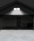 Dusk to Dawn LED Security Light 18W Plug-In Outdoor Flood Light 5000K Daylight 1600LM illuminating a garage exterior at night