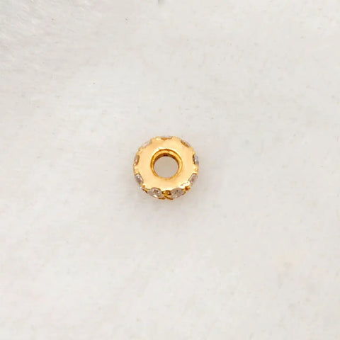 Totally Legit 14k Solid Yellow Gold Pave Diamond 4mm Wheel Spacer Bead on a soft surface, showcasing sparkling pave gems.
