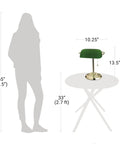 Diagram showing 13.5 Inch Traditional Banker Lamp with Green Glass Cylinder Shade and Polished Brass Finish next to human silhouette.
