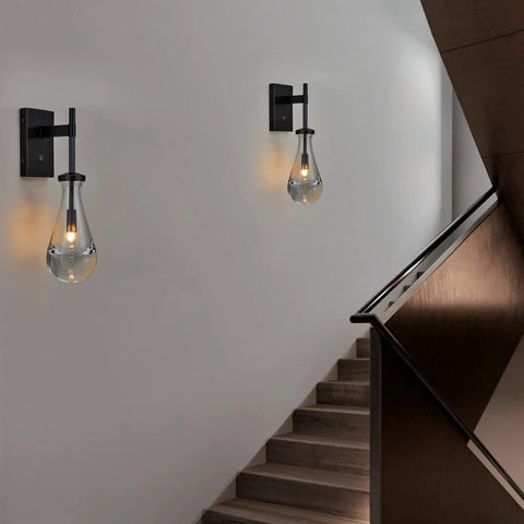 Black Raindrop Glass Wall Sconce With On Off Switch Sleek Modern Vanity Light Fixture illuminating hallway stairs for ambience.