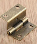 Close-up of a zinc alloy cabinet hinge from 4 Pack Zinc Alloy Cabinet Hinge Set For Cabinets, Jewelry Boxes, And Small Furniture 25x15x12mm With Screws Built To Last For Wood Boxes And Drawer Doors, shown on a wooden surface.