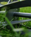 Close-up of the 7-blade ball bearing reel of a 16-Inch Push Reel Lawn Mower with grass, showing steel blades in motion.