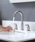 Widespread 3 Hole Bathroom Faucet Kit In Brushed Nickel, 8 Inch Spread, two handles, running water into glass on white sink