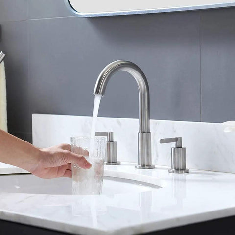 Widespread 3 Hole Bathroom Faucet Kit In Brushed Nickel, 8 Inch Spread, two handles, running water into glass on white sink