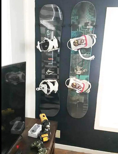 Beefy Ski And Snowboard Wall Mount Storage Rack invisible floating display showcasing two boards with bindings mounted on a dark wall.