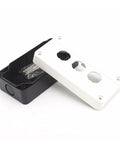 Junction box cover, white plastic with three knockout holes, atop black base (front-angle view)