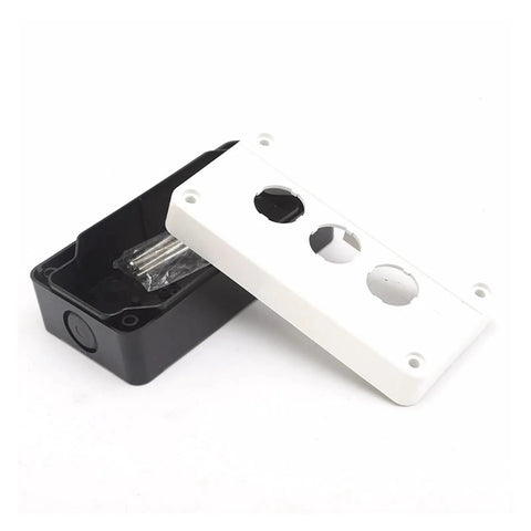 Junction box cover, white plastic with three knockout holes, atop black base (front-angle view)