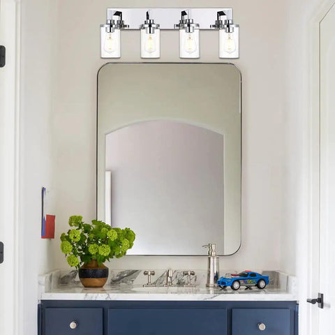 Sleek Chrome Finish Four Light Bathroom Vanity Light Fixture With Clear Glass Shades above modern bathroom sink and mirror.