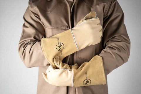 Person wearing stick welding gloves heat resistant with pro grade premium grain cowhide leather heavy duty cotton lining.