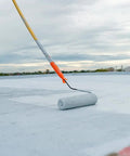 Heavy Duty Liquid Waterproofing Membrane Multi Surface Crack And Leak Repair Coating Interior Exterior Water Based Moisture Blocker Heavy Duty Sealant Easy Brush Application 5 Gallon Sandy Beige being applied with a roller on a roof.