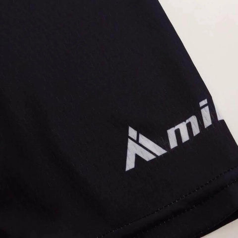 Close-up of black fabric with a partial logo showing the letters "mi."