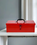 Tough As Nails Red Metal Toolbox Organizer With Secure Latch Closure And Rugged Portable Handle on white desk.