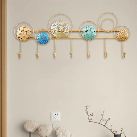 Heavy Duty Wrought Iron Wall Decor With A Dope Partition Rack And Coat Hook This Hand Painted Blue Gold Storage Organizer Sets An Awesome Vibe While Keeping Things Sleek on a wall with circular metal designs and hooks.