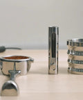 Premium Retractable Espresso WDT Tool All Stainless Steel Coffee Distribution Needle next to portafilter filled with grounds.