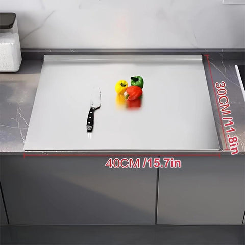 Front view of stainless steel kitchen cutting board, 40×30 cm, on a counter with knife and peppers