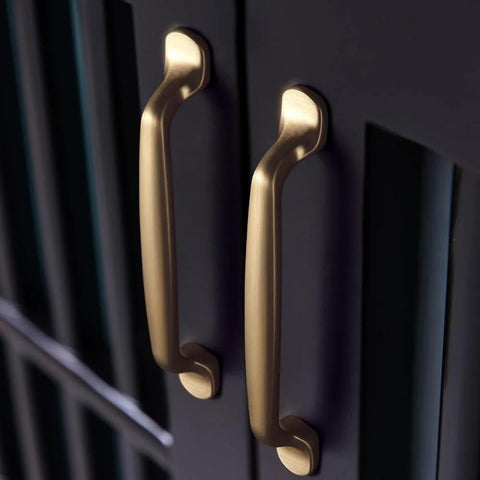 Six Pack 5 Inch Center To Center Arch Cabinet Pulls In Champagne Bronze Finish made from zinc alloy installed on dark cabinets.