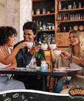 Group of friends enjoying coffee at a cafe, holding cups and smiling, seated at a wooden table with a coffee-themed decor backdrop.