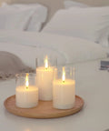 Clear Glass Flameless Candles With Timer And Remote Control Battery Powered LED Pillar Candles Set Of 3 In White Wax on a tray