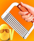 Crinkle cutter with wooden handle and stainless steel blade, held in hand against orange background