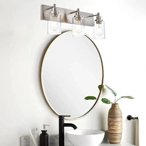Dope Brushed Nickel Bathroom Light Fixture With Clear Glass Shade above round mirror in modern bathroom setting
