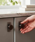 Hand using Nordic Style Cabinet Handles in walnut wood and zinc alloy for kitchen drawers, ergonomic single hole mount