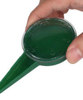 Hand holding a Spreader Seed Planter for Gardens and Farms, Manual Seed Seeder Tool, Handy Adjustable Handheld Seed Spreader, green plastic