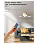 Hand holding remote control for kousoer Ceiling Fans Quiet Remote USB 7200mAh in a modern living room.