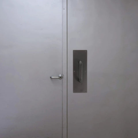 304 Stainless Steel Push Pull Door Handle With Screws For Fireproof Passages installed on a metal door.