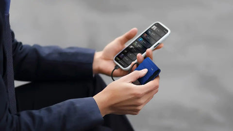Person holding T7 Shield 1TB Portable External SSD Up To 1050 MB Per Second USB 3.2 Gen2 Rugged IP65 Weatherproof Drop Resistant