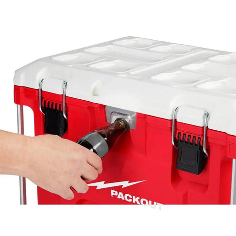Hand using drain plug on PACKOUT 40QT XL Cooler Box with impact resistant polymer body, showing modular design and durability.