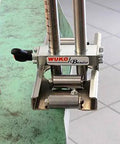 Close-up of Uni Bender 2204 Heavy Duty Metal Bending Tool for 90 Degree Angles with built-in 1/8 inch scale ruler on green surface.
