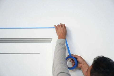 Applying Blue Multi-Surface Painter's Tape 1.88 Inch By 60 Yards, 12 Rolls for clean lines on a wall edge